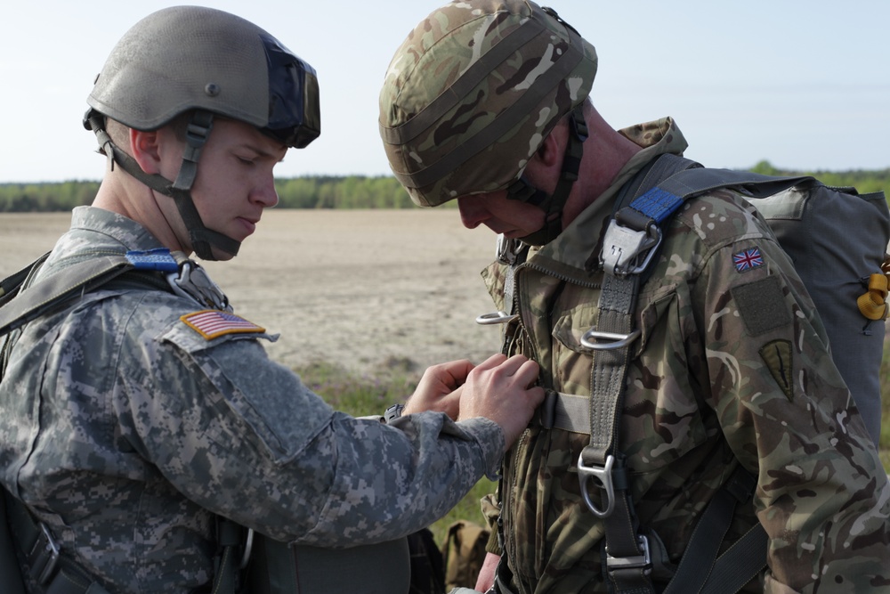 U.S. Army soldier assists a Cpl. from the Royal Army