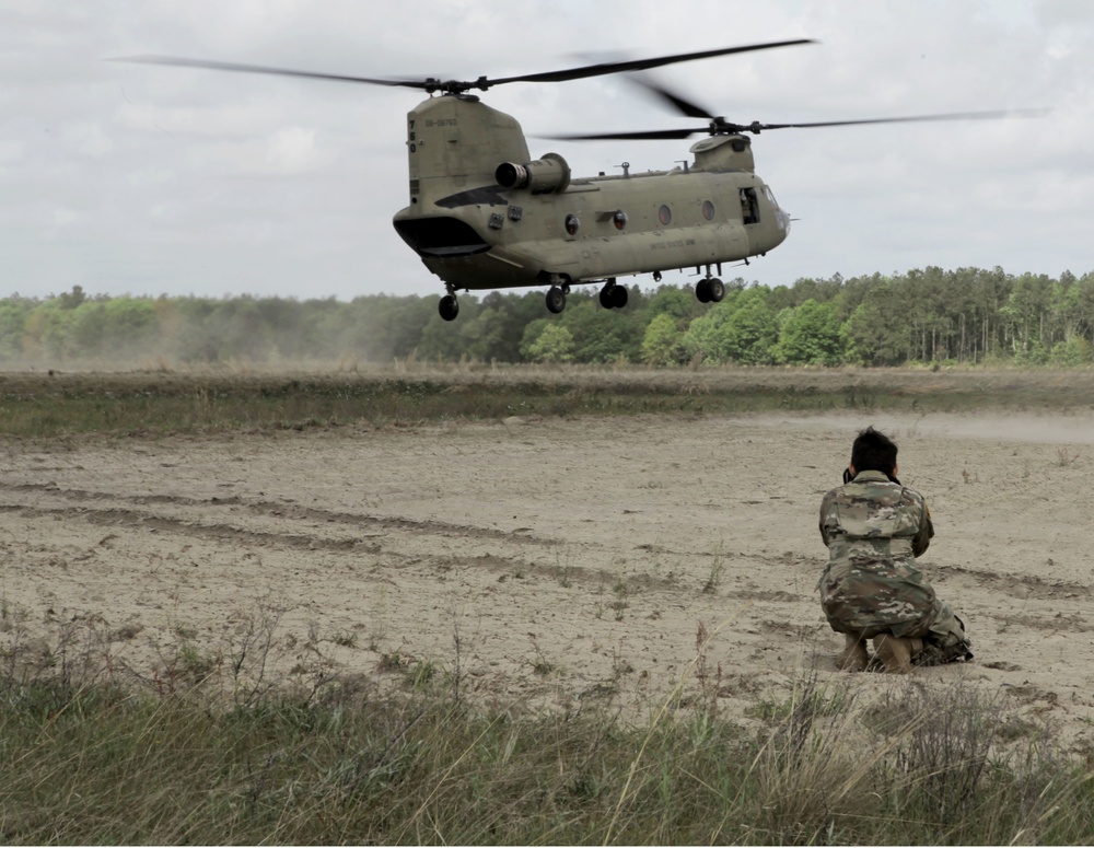 Army CH-47 takes off from an airfield.