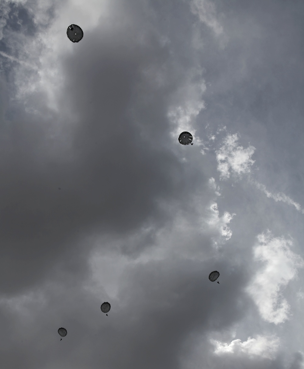 Paratroopers descend onto an airfield