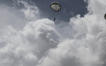 Paratroopers descend onto an airfield