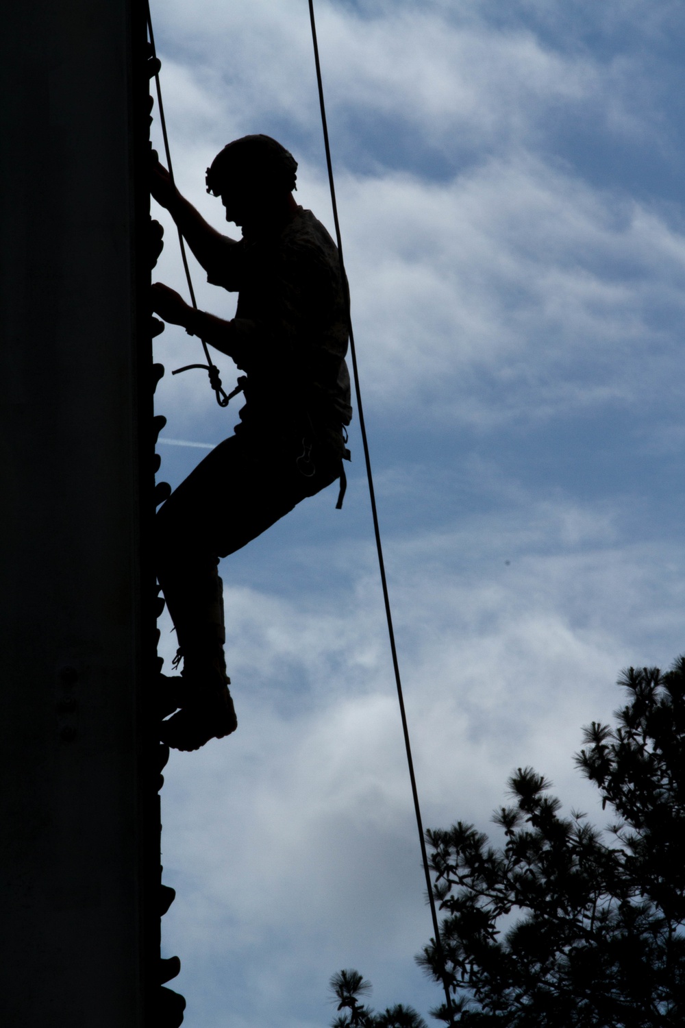 Army Ranger climbs a wall during a competition