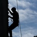 Army Ranger climbs a wall during a competition