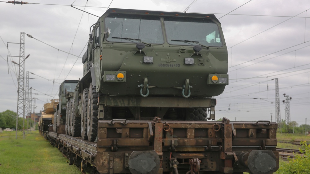 U.S. Marines team up with locally-sourced contractors to offload mechanized equipment
