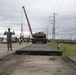 U.S. Marines team up with locally-sourced contractors to offload mechanized equipment