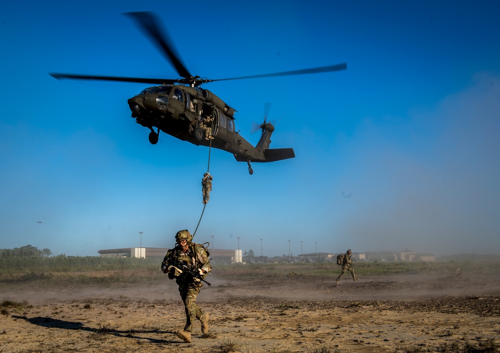 Men fast roping out of a helicopter.