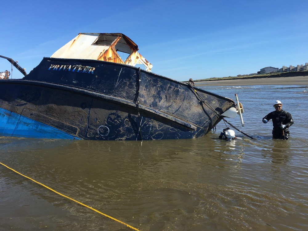 Salvage experts attempt to salvage beached fishing vessel