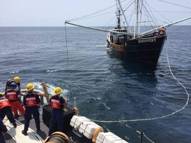 Coast Guard Cutter Sanibel throws a towline to fishing vessel Discovery