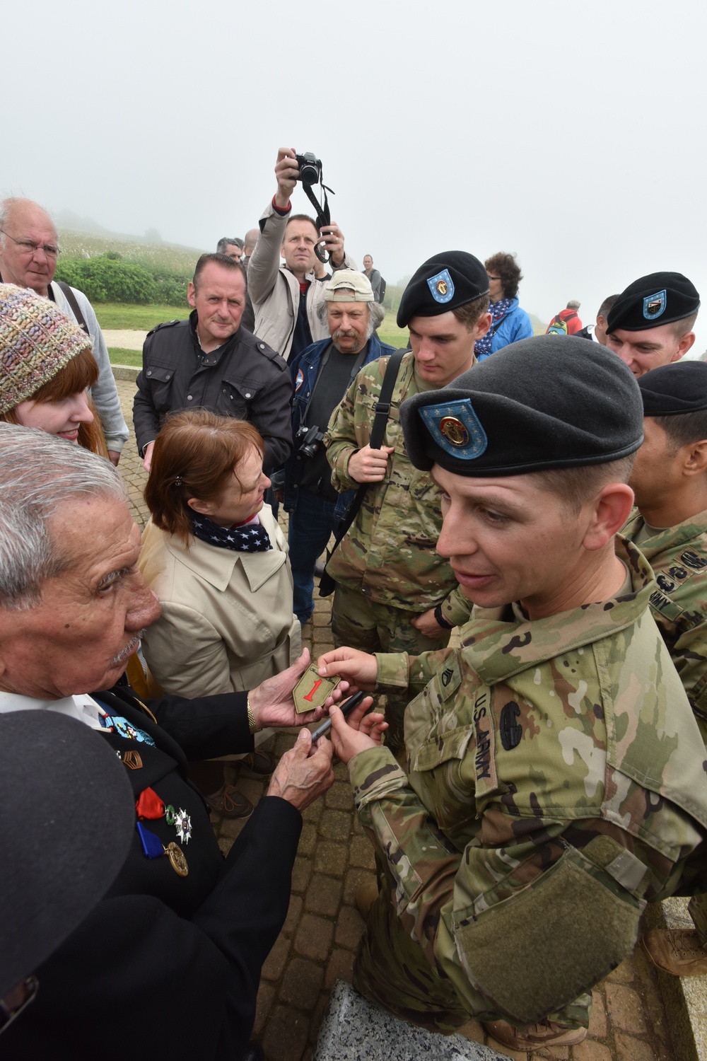 1ID veteran meets and signs patches of 1ID Soldiers at Omaha Beach memorial ceremony