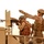 Two soldiers are positioned on the bed of a military vehicle in an arid desert environment. One soldier is operating a mounted machine gun while a second soldier in digital camouflage uniform and sunglasses gestures with an outstretched arm, appearing to direct or instruct. The scene suggests a training or operational scenario in a desert theater.