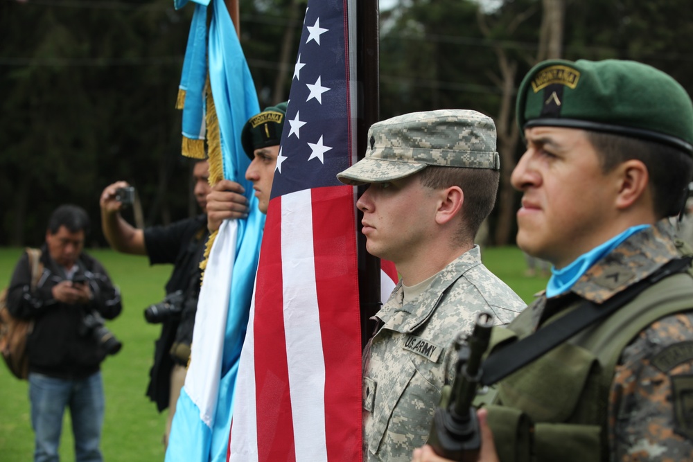 Spc. Mathew Thompson holds the American flag with Guatemalan color guard.