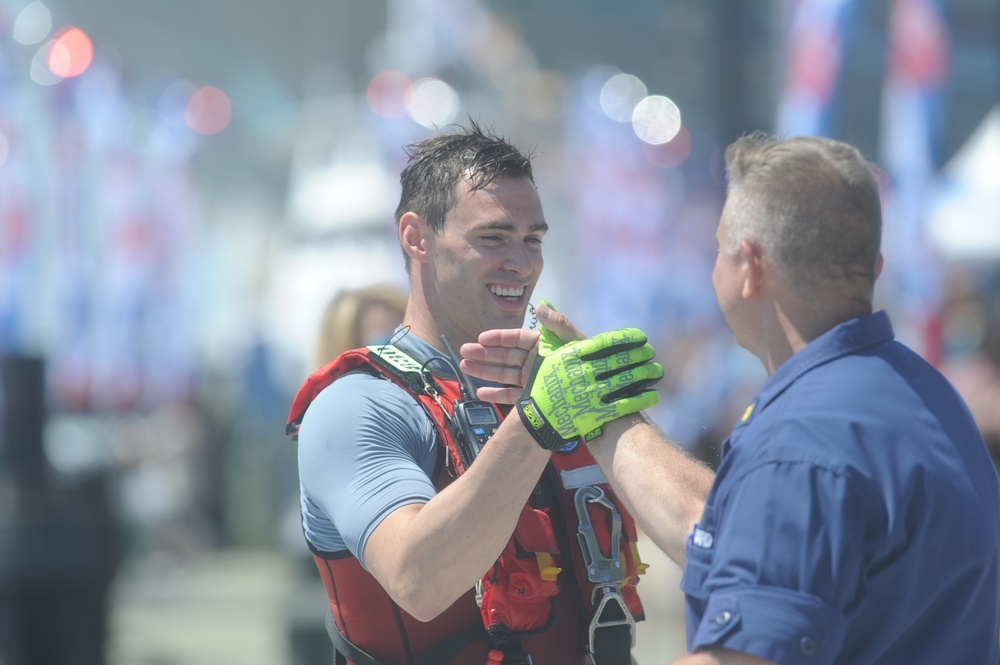 Coast Guard rescue swimmer congratulated by Chief Warrant Officer Gall