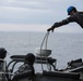 Australian sailors launch a rigged hull inflatable boat off HMAS Adelaide