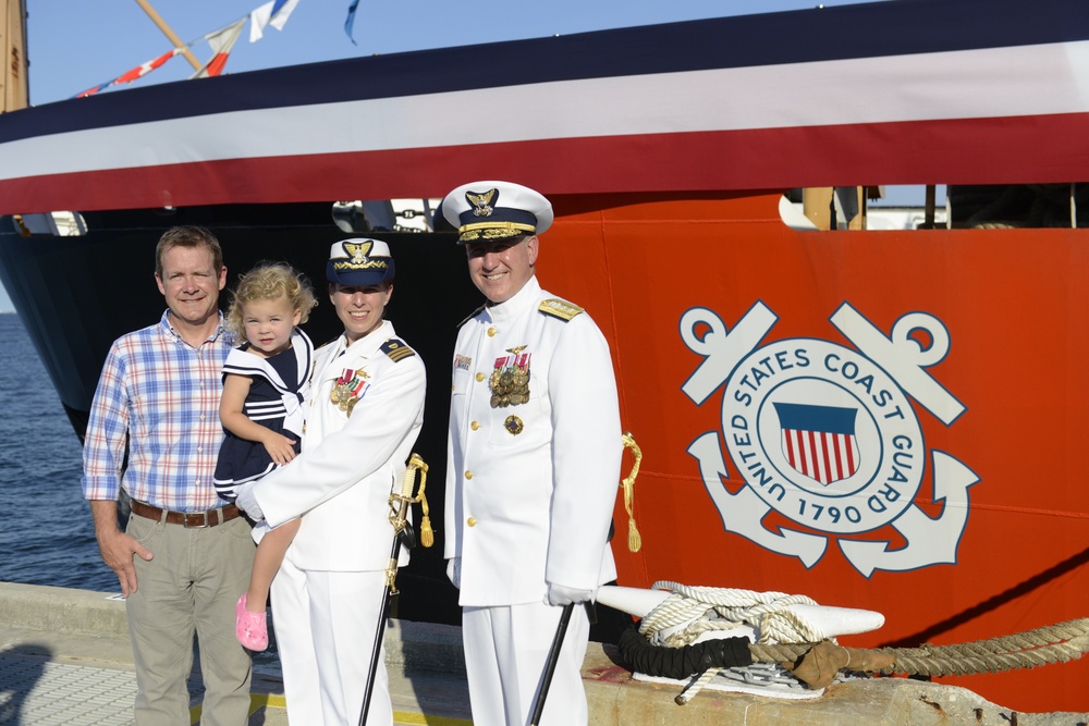 Rear Adm. Callahan stands with Cmdr. Florentino and her family in front of the Coast Guard Cutter Cypress