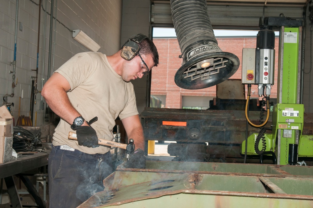 Metal Worker Hammers Out Bolts