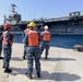 Sailors stand by as the aircraft carrier USS Harry S. Truman (CVN 75) arrives at Naval Support Activity Souda Bay