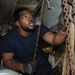 Machinist Mate 3rd Class Michael Walker pulls on a chain that's connected to a pulley aboard the amphibious assault ship USS Bataan (LHD 5).