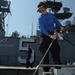 Airman Recruit Lane Sullivan uses a power washer on the flight deck of the amphibious assault ship USS Bataan (LHD 5).
