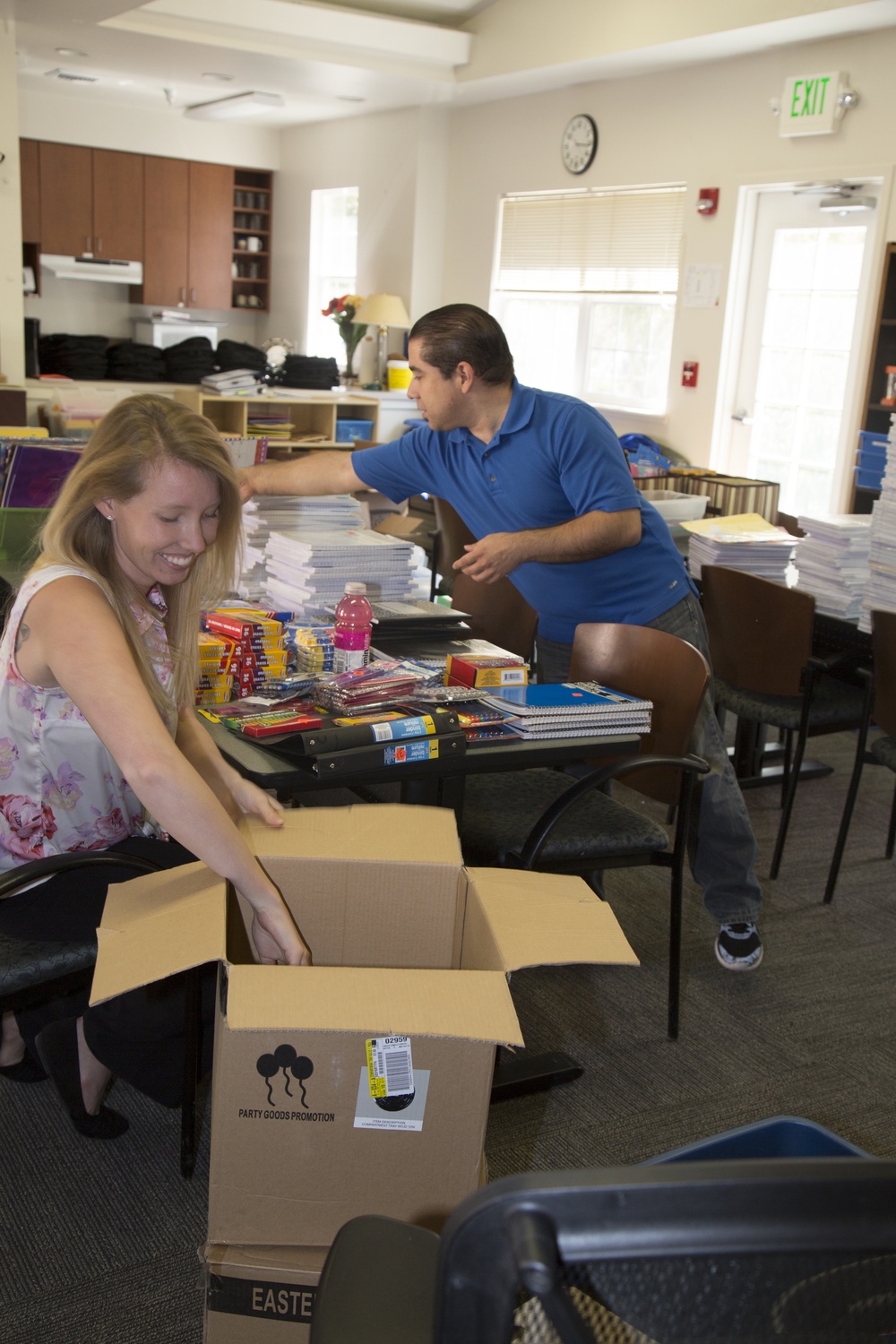 Ashley Ignatz, trainer with Marine Corps Family Team Building and Adam Diaz, Exceptional Family Member Program case worker and School Liaison Program officer sort, count and ready supplies for the Back to School Brigade held aboard Marine Corps Logistics