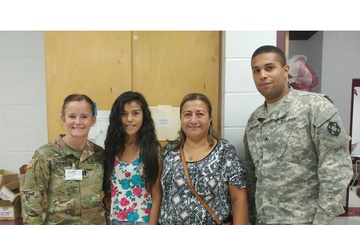 Army Reserve service members take time for photo with local community members during Operation Lone Star