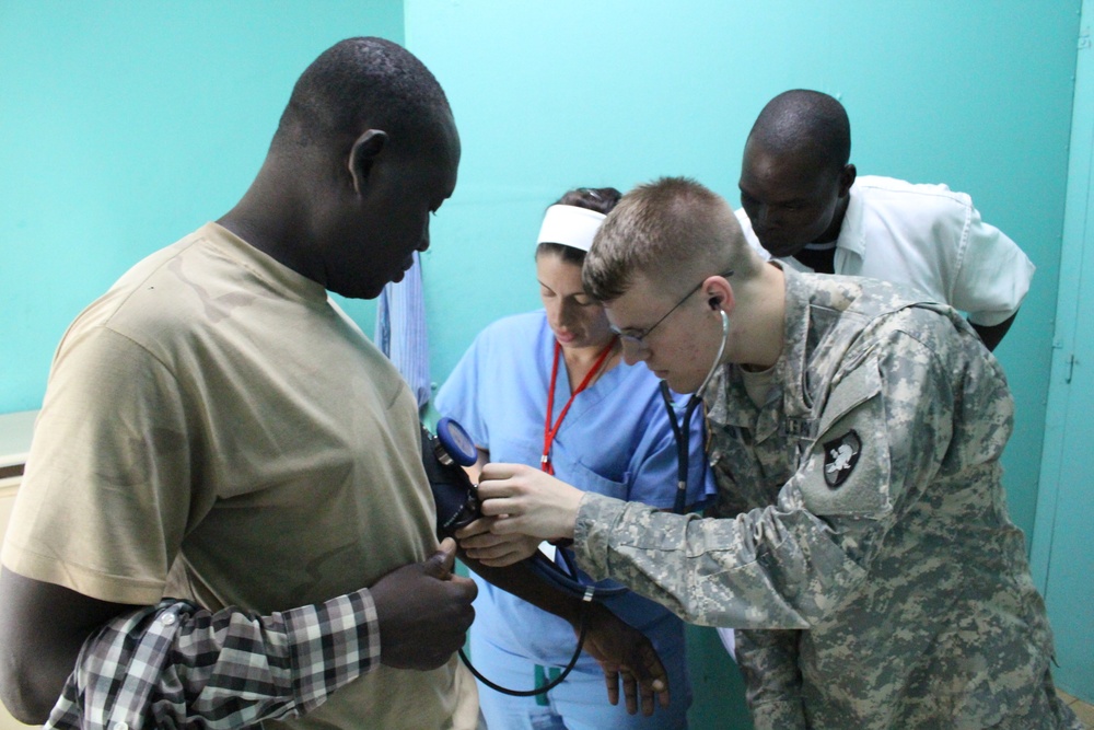 United States Military Academy cadet listens as Army Reserve nurse instructs in Chad hospital