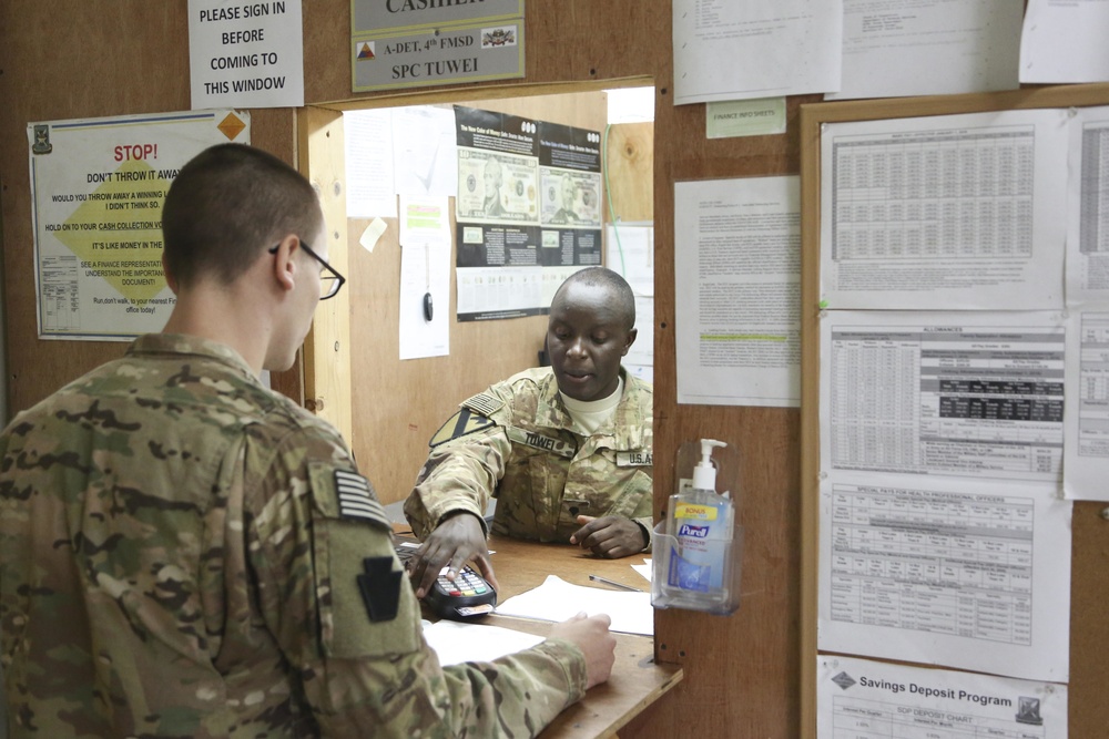 Soldier assists with Eagle Cash card