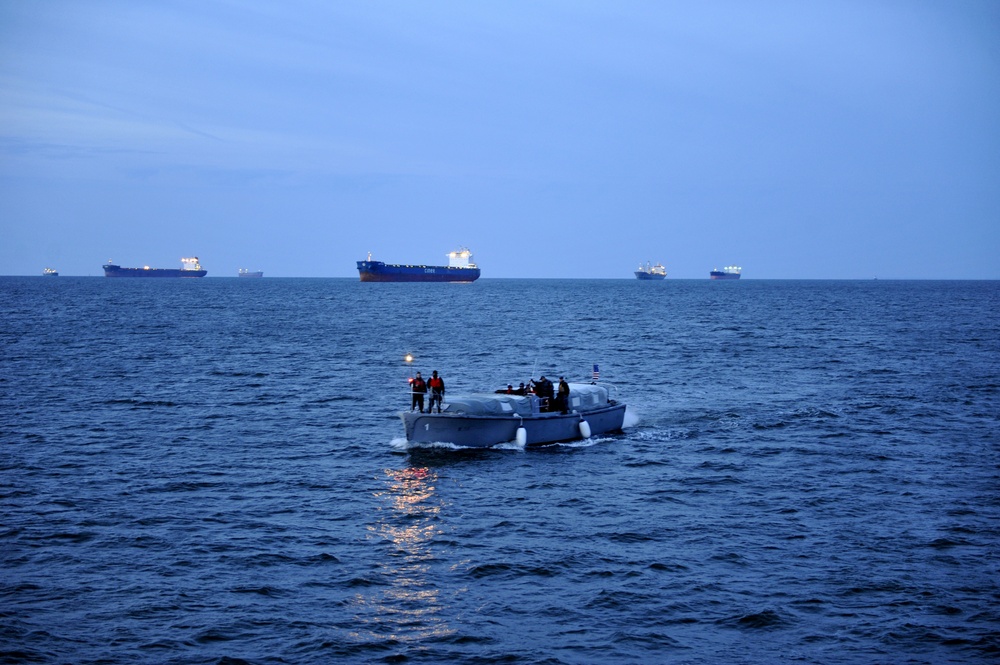 Crewmembers from the Naval Academy transport passengers to the Coast Guard Cutter Eagle