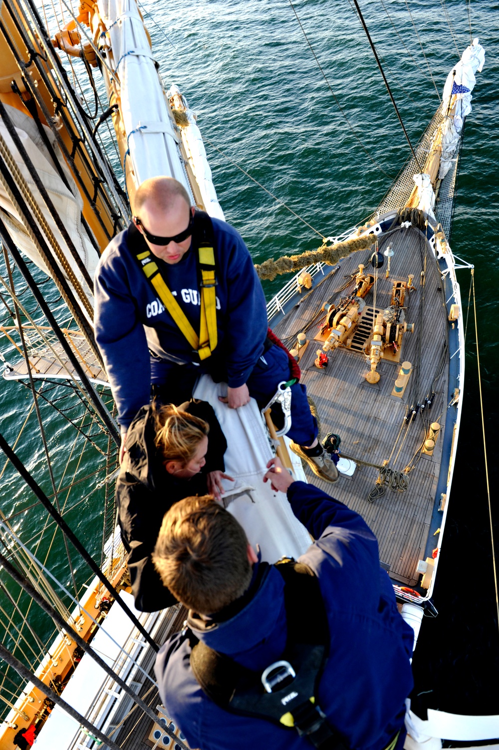 Coast Guard Cutter Eagle crewmembers repair damaged sails while underway