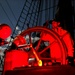 Coast Guard Cutter Eagle crewmember mans the helm under a full moon