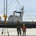 Shipmates aboard the SS Wright participate in experimental loading techniques