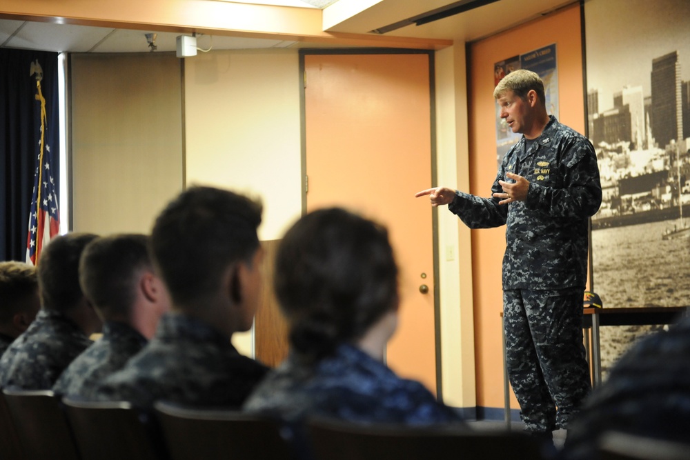 Commander, Submarine Squadron 11 speaks to midshipmen