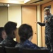 Commander, Submarine Squadron 11 speaks to midshipmen