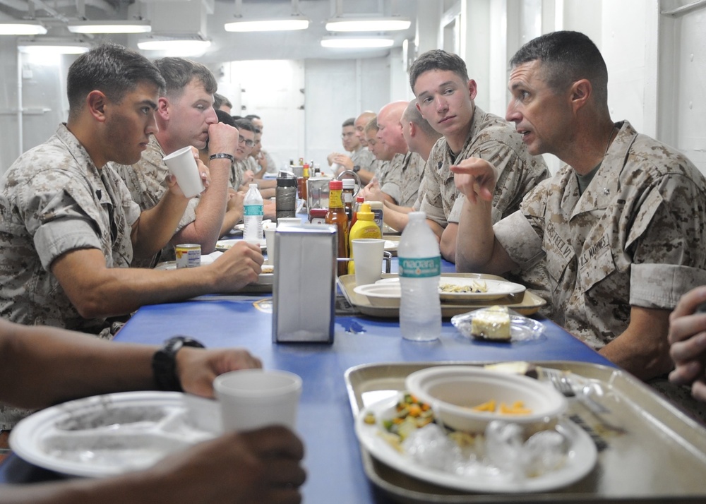 Brig. Gen. Robert F. Castellvi, Deputy Commanding General speaks with Marines during lunch on the mess decks of the amphibious assault ship USS Bataan (LHD-5).