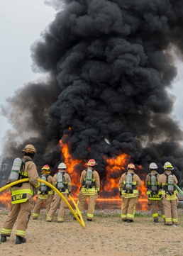 Firefighters watch fuel-fire build