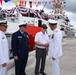 Rear Admiral Scott Buschman, Commander of the Coast Guard 7th District, presents Walt Slater, U.S. Navy Retired Motor Machinist's Mate 3rd Class, with a coin after the commissioning ceremony of the 18th Fast Response Cutter.