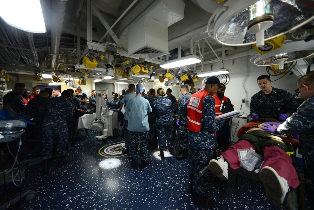 Sailors assigned to the amphibious assault ship USS Bataan (LHD 5), Fleet Surgical Team 6 and Naval Medical Center Portsmouth work together to give medical care to simulated patients during a mass casualty drill in the medical triage aboard Bataan.