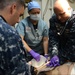 Sailors assigned to the amphibious assault ship USS Bataan (LHD 5), Fleet Surgical Team 6 and Naval Medical Center Portsmouth work together to give medical care to a simulated patient during a mass casualty drill in the medical triage aboard Bataan.