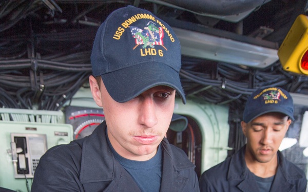 Sailor mans the helm on the bridge aboard USS Bonhomme Richard (LHD 6)