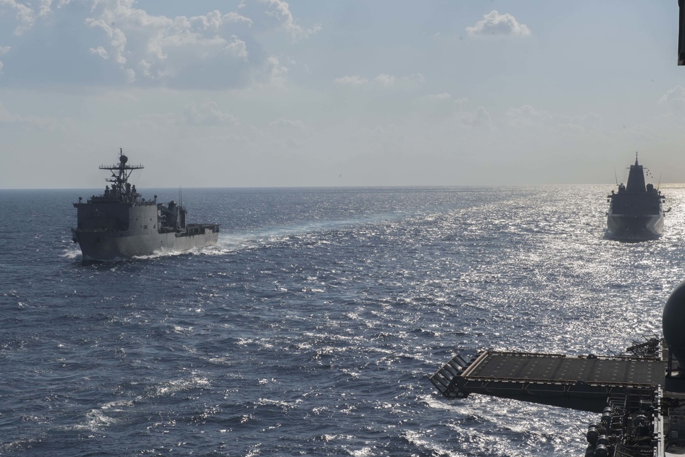 Amphibious dock landing ship USS Germantown (LSD 42) (left) and amphibious transport dock ship USS Green Bay (LPD 20) transit behind amphibious assault ship USS Bonhomme Richard (LHD 6).