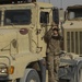 Soldier cleans mirror on her M915A3 truck