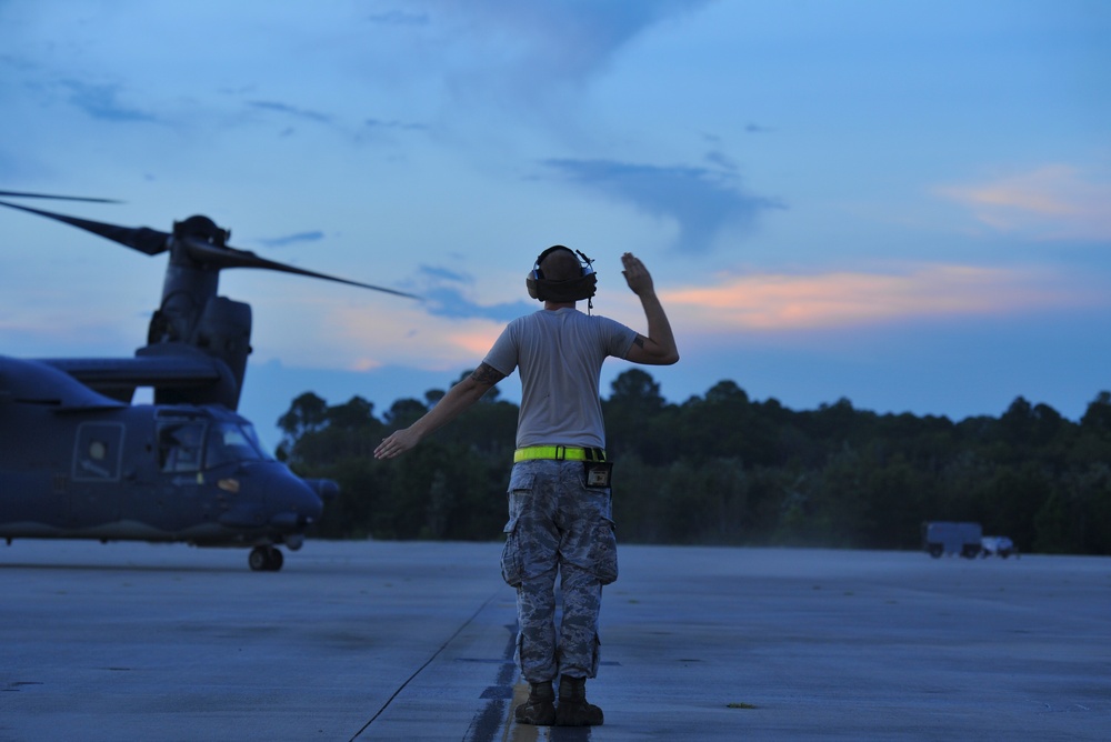 Crew chiefs guide in a CV-22B Osprey