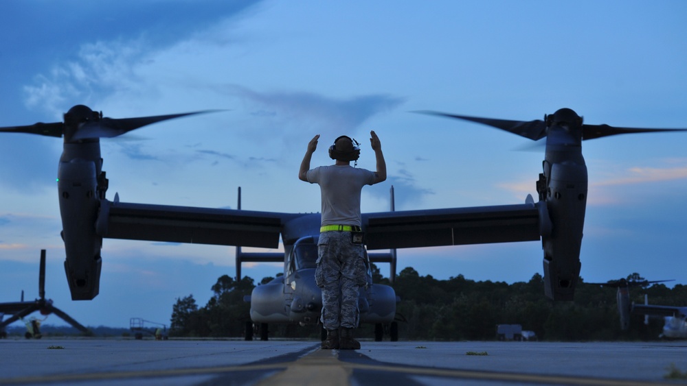 Crew chiefs guide in a CV-22B Osprey