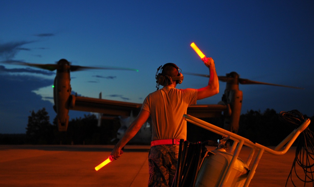 Crew chiefs guide in a CV-22B Osprey