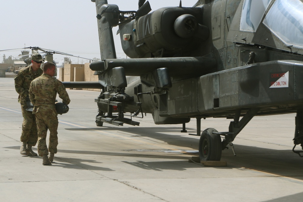 Soldiers load rockets, missiles on Apache attack helicopter