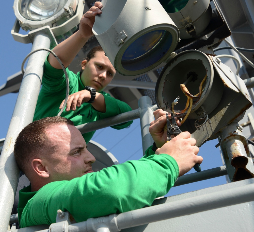 Sailors repair flight deck spotlight