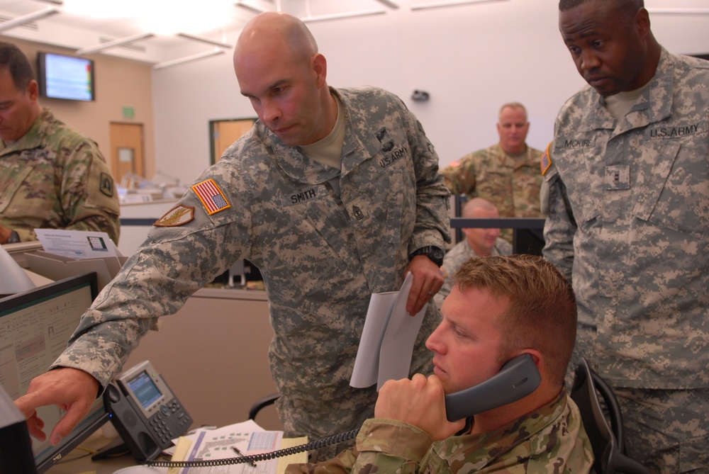 CAMP BLANDING, FL – Florida National Guard Soldiers 1st Sgt Timothy Smith, Capt. Kirk Strander and CW2 Joseph McKire discuss hurricane response at the Joint Operations Center during Hurricane Matthew.