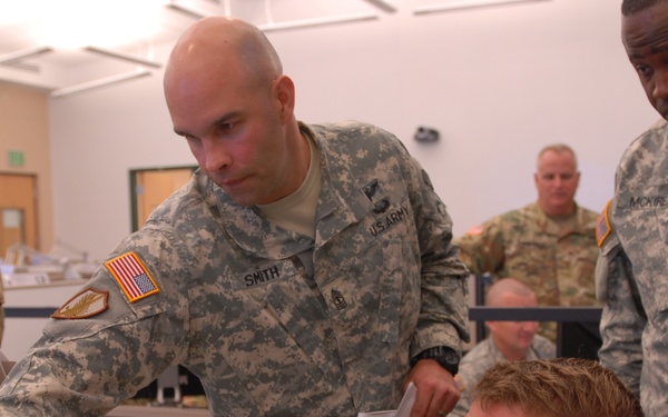 CAMP BLANDING, FL – Florida National Guard Soldiers 1st Sgt Timothy Smith, Capt. Kirk Strander and CW2 Joseph McKire discuss hurricane response at the Joint Operations Center during Hurricane Matthew.
