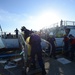 Crew members aboard the Coast Guard Cutter Spencer bring trash cans ashore to empty them after being underway.