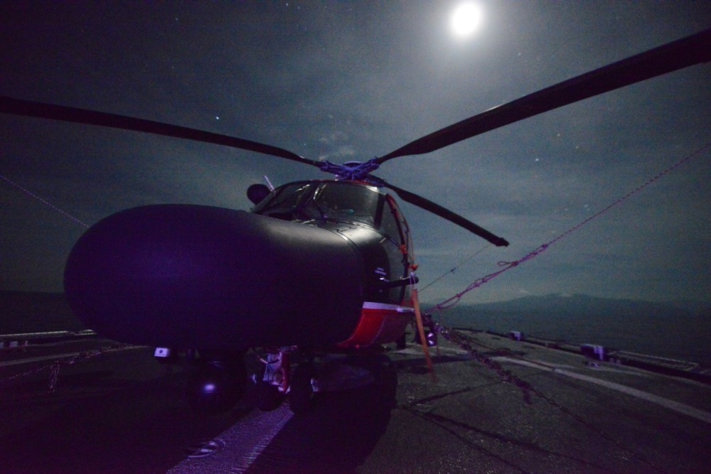 Moon light shines on a Coast Guard Air Station Borinquen MH-65 Dolphin helicopter aboard the Coast Guard Cutter Spencer.