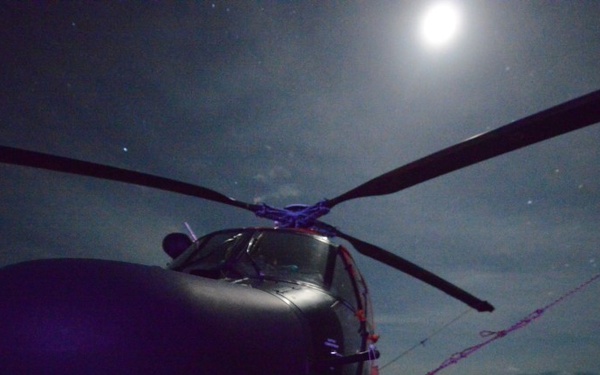 Moon light shines on a Coast Guard Air Station Borinquen MH-65 Dolphin helicopter aboard the Coast Guard Cutter Spencer.