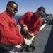 Sailors conduct maintenance on a firefighting equipment